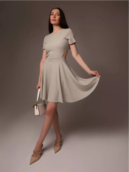 Model in a stylish Breezy Hour mini dress, a chic summer dress with a cutout detail and flared hem.