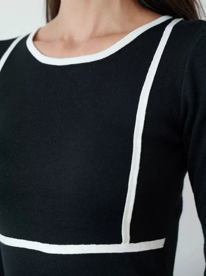 Close-up of Frame Midi Dress in black with white contrast trim, showcasing elegant minimalist design and soft knit material.