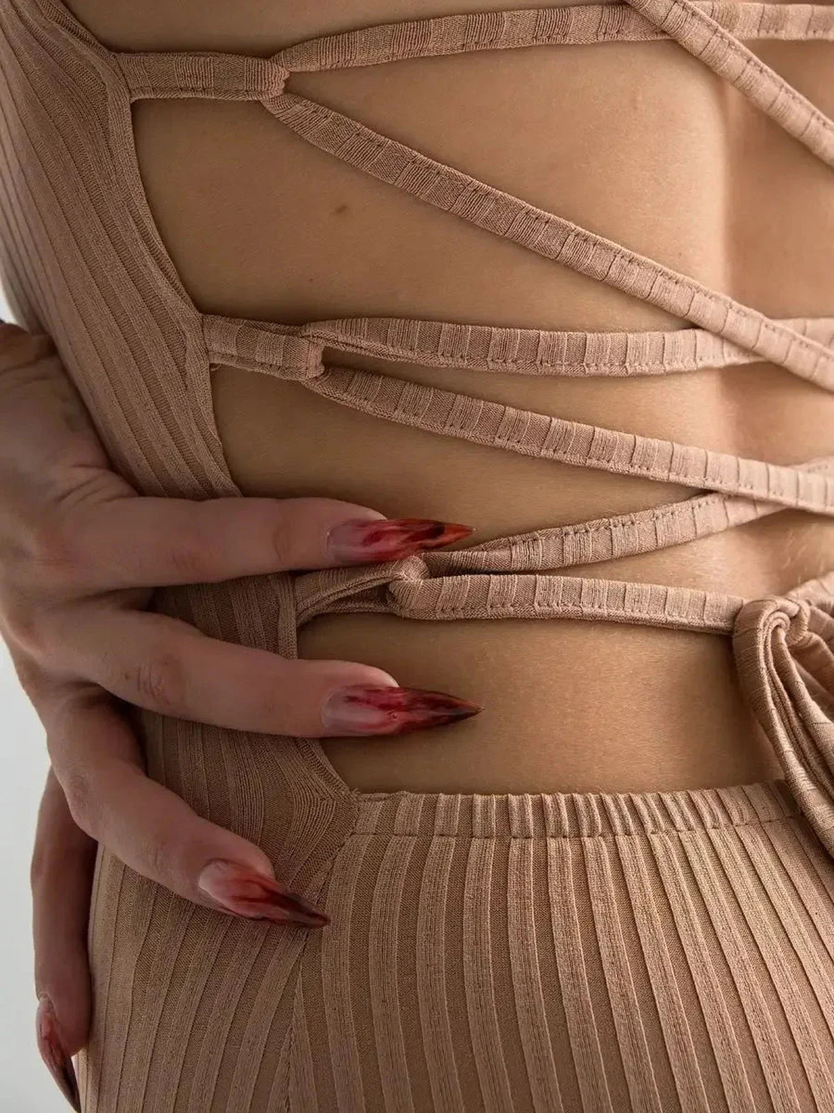 Close-up of a nude lace midi dress featuring a corset back design and sculpting ribbed texture.