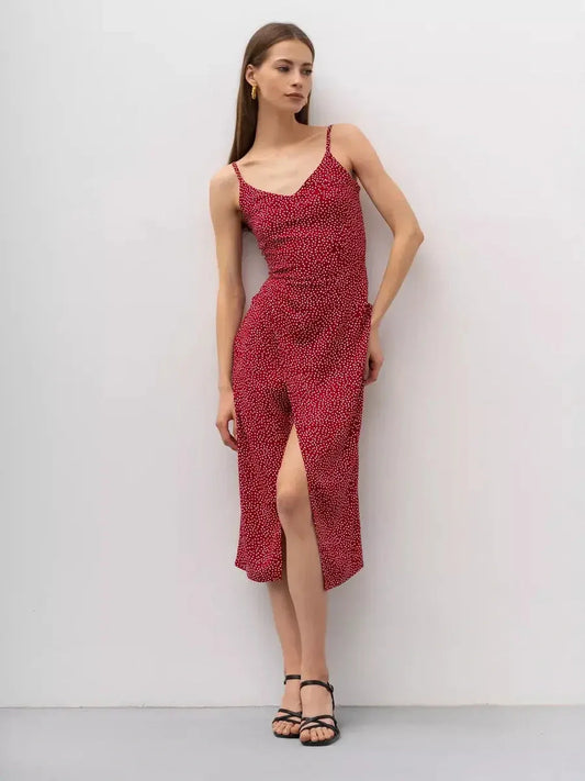 Model wearing a Cherry Dots Midi Dress in red with white polka dots, featuring a stylish wrap design.