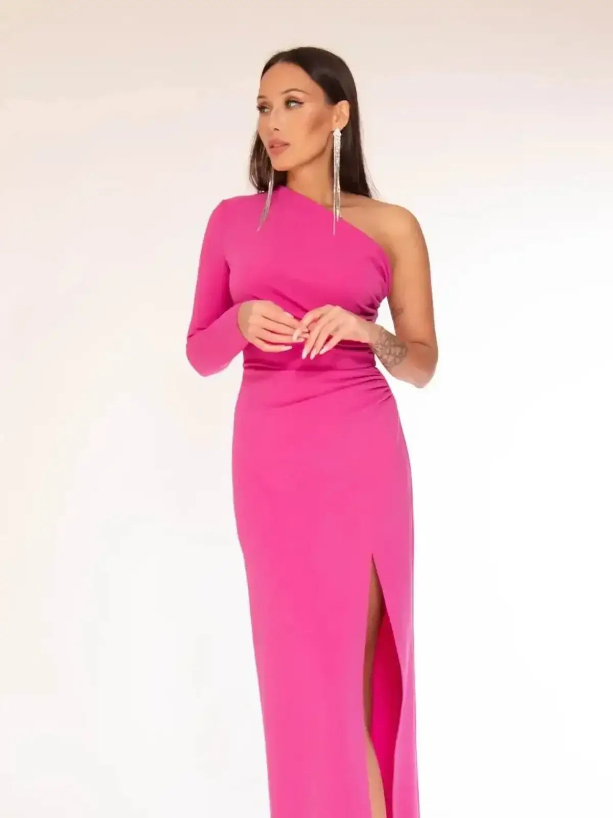 Vibrant pink maxi dress in a one-shoulder design with a dramatic thigh-high slit, perfect for weddings and formal events.