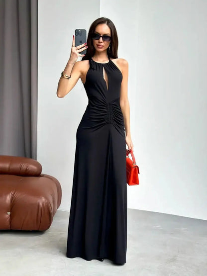 Elegant black maxi dress with halter neckline and draped detail, perfect for weddings and formal events.