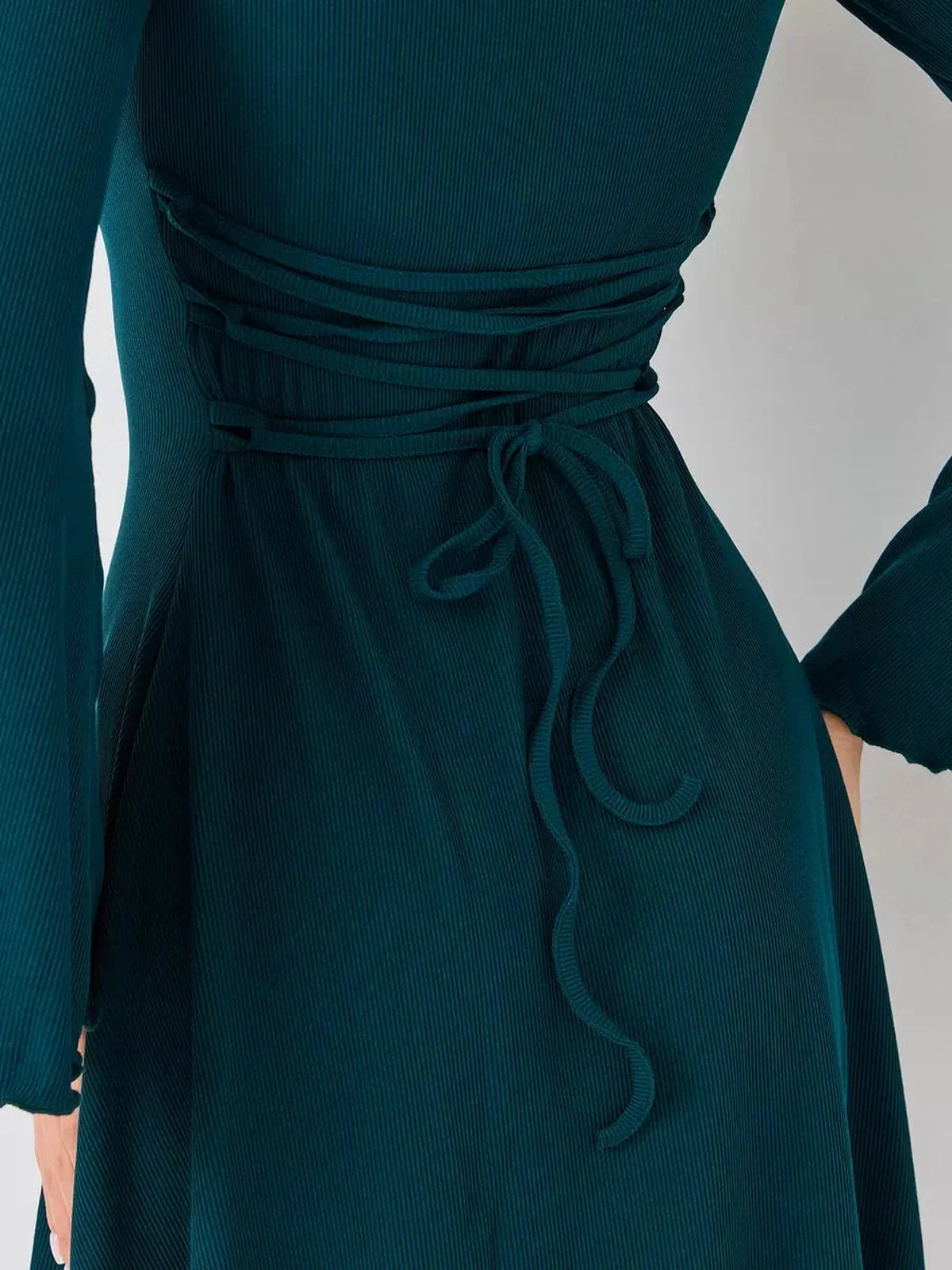 Detail of the Emerald Whisper mini dress, featuring a stylish tied back design in rich emerald green.