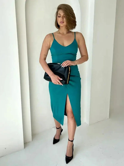 Elegant woman in a teal satin midi dress with thigh-high slit and black clutch, perfect for formal events.