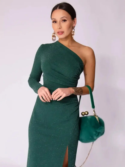 Model showcasing the Emerald Spark Maxi Dress, a one-shoulder green dress with shimmer and a high side slit.