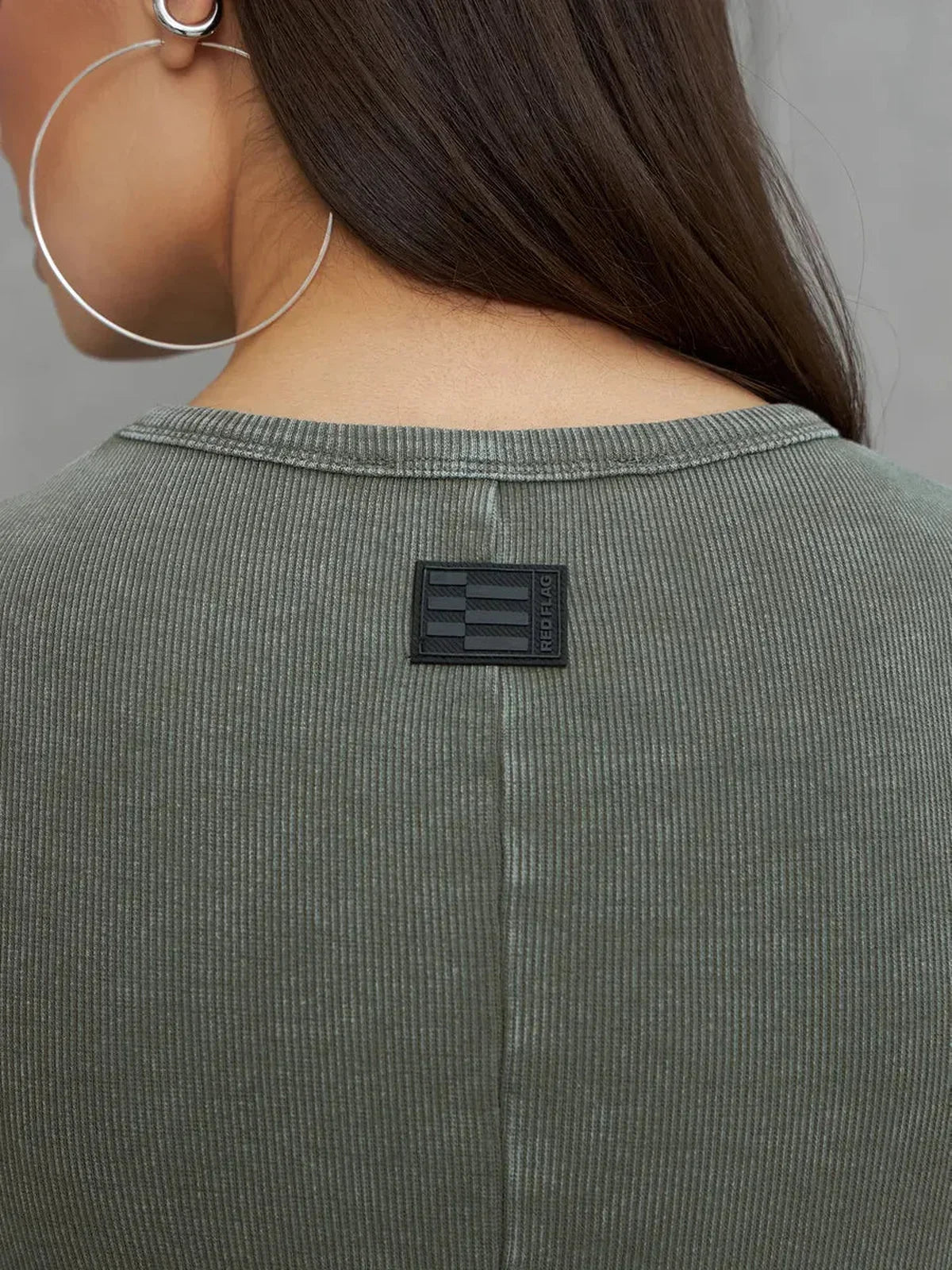 Detail view of the Olive Line Maxi Dress showing the back neckline and brand tag in khaki ribbed cotton.