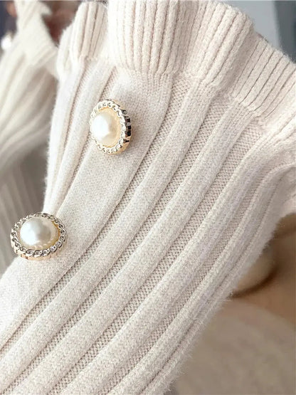 Close-up of ribbed knit fabric with decorative pearl buttons, highlighting elegant details for women's fashion.