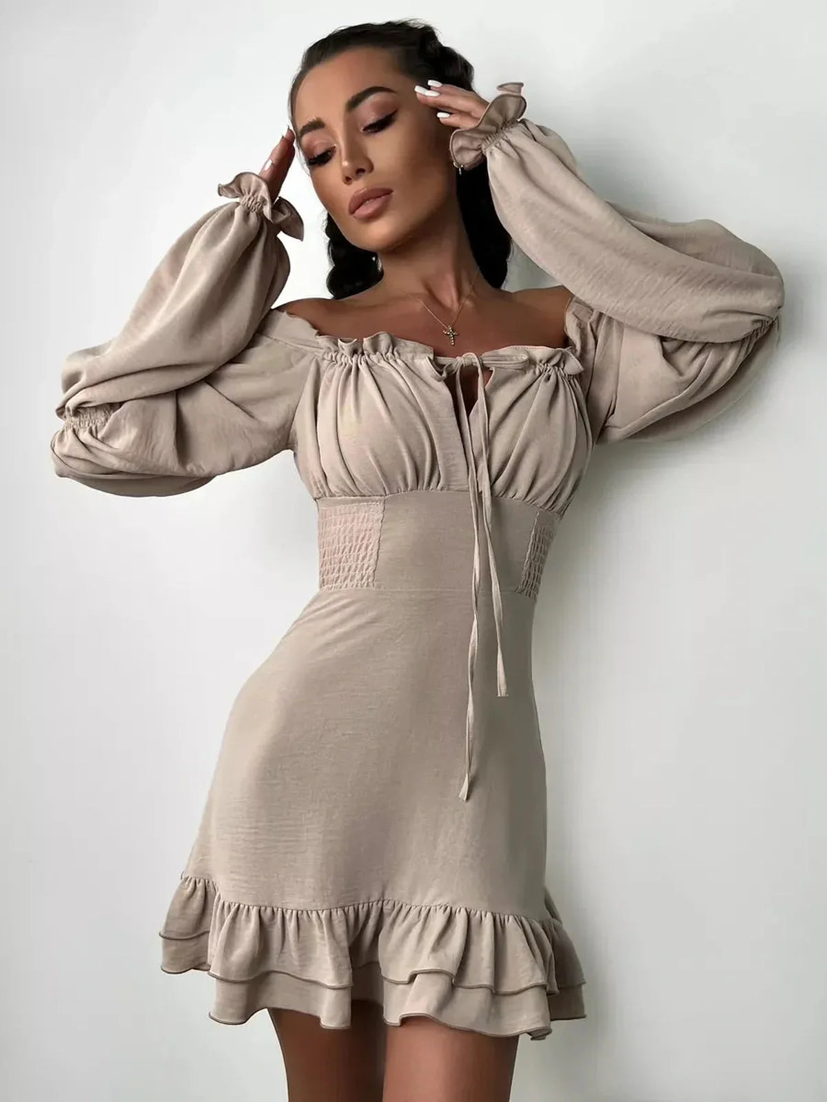 Beige off-shoulder Ruffle Muse Mini Dress featuring puff sleeves and a flounced hemline, perfect for summer events.