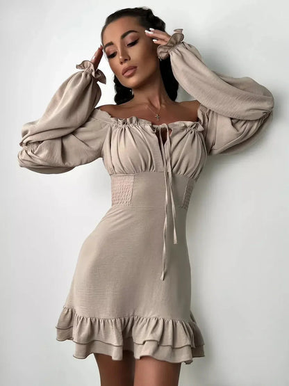Beige off-shoulder Ruffle Muse Mini Dress featuring puff sleeves and a flounced hemline, perfect for summer events.