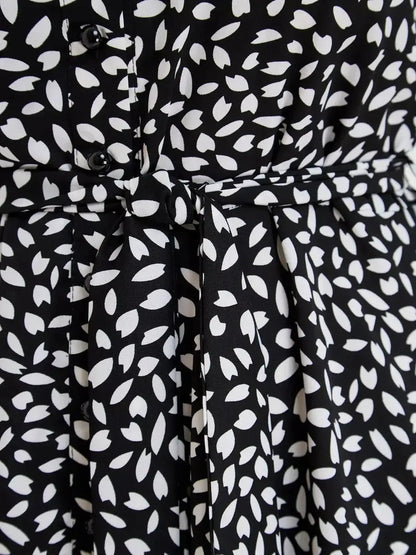 Close-up of Monaco Midi Dress showcasing the black and white print, button details, and waist tie for a flattering silhouette.