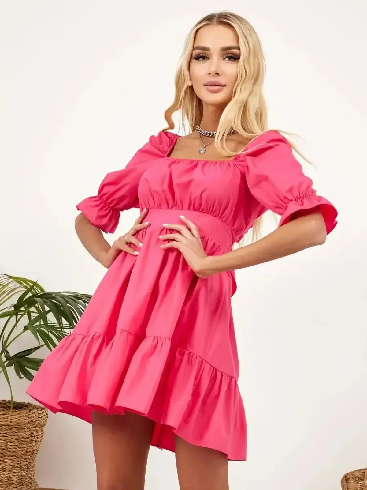 Stylish woman wearing a pink Candy Bow mini dress, perfect for summer parties and wedding guest occasions.