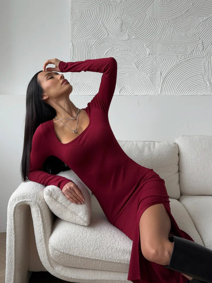 Model showcasing the Ribbed Grace Midi Dress in burgundy, featuring a side slit and elegant silhouette.