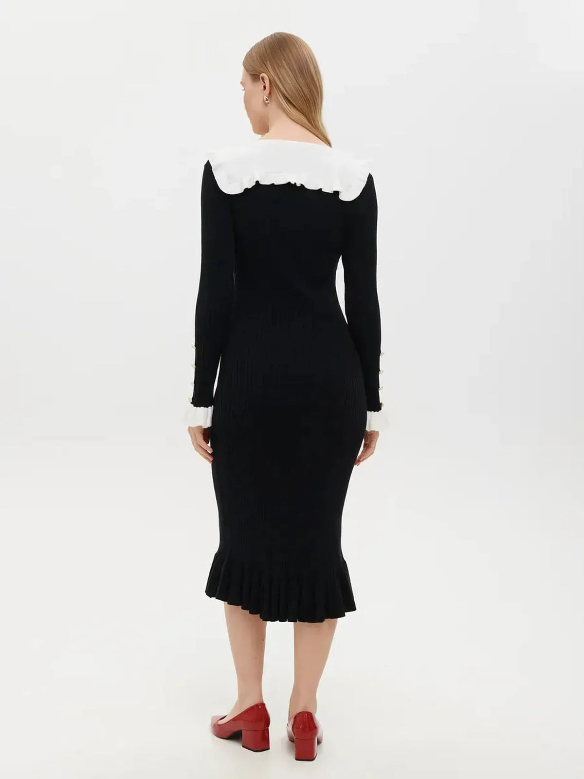 Back view of a Ruffle Collar Midi Dress in black featuring a creamy white ruffle collar and sleeve cuffs.