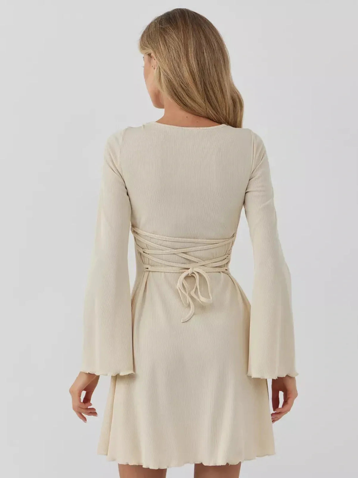 Back view of Sculpted Grace mini dress featuring long sleeves and stylish tie detail for a customized fit.