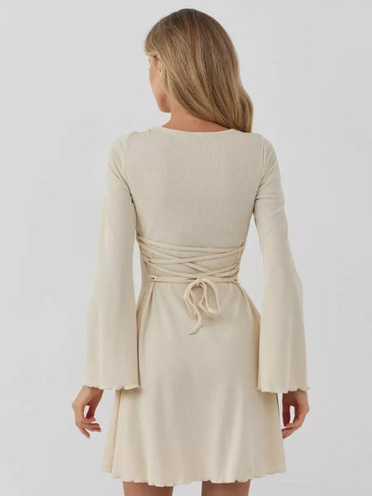 Back view of Sculpted Grace mini dress featuring long sleeves and stylish tie detail for a customized fit.