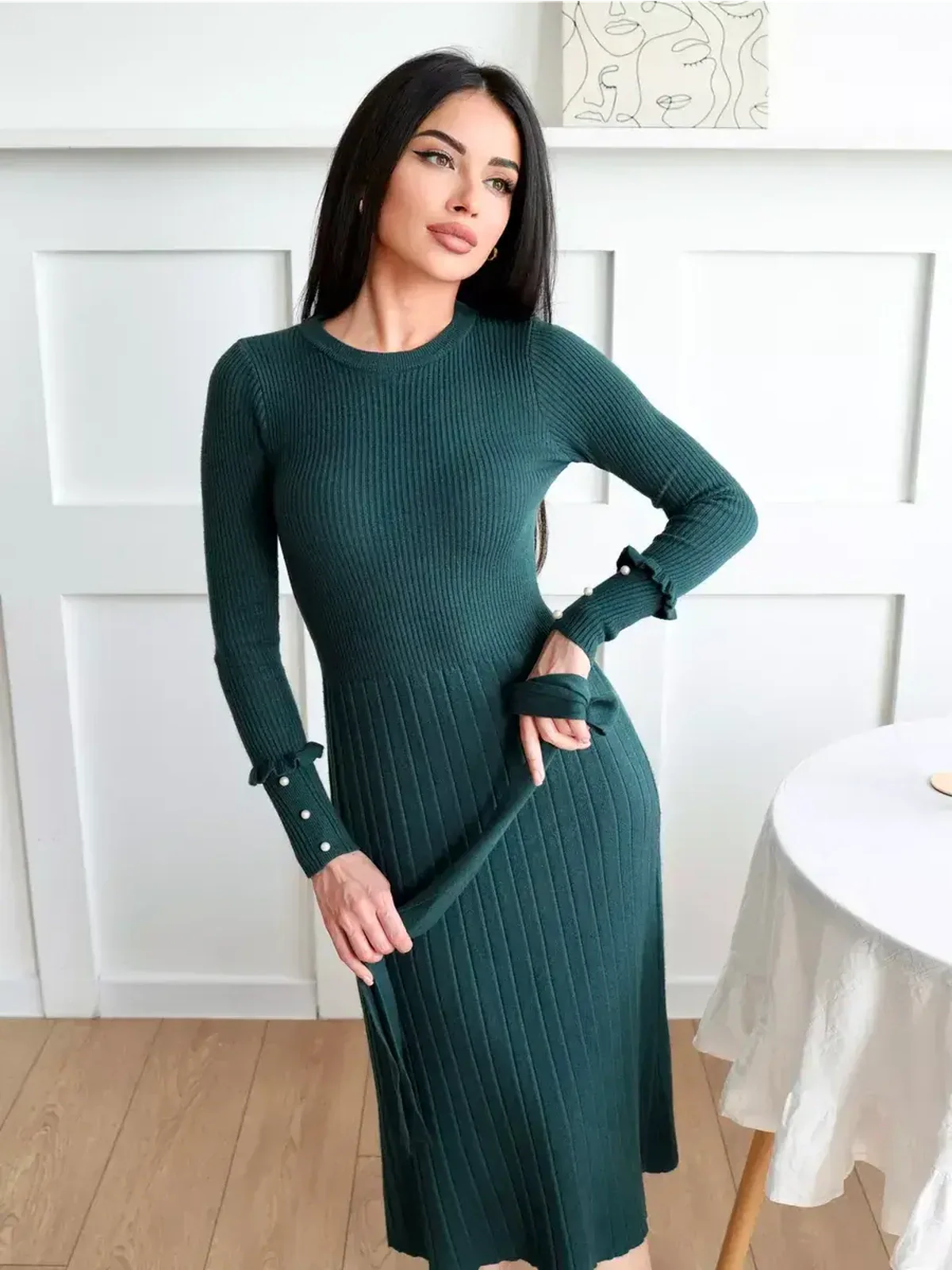 Model wearing the Emerald Grace Midi Dress in ribbed knit emerald green, featuring pearl-style accents and a flattering silhouette.