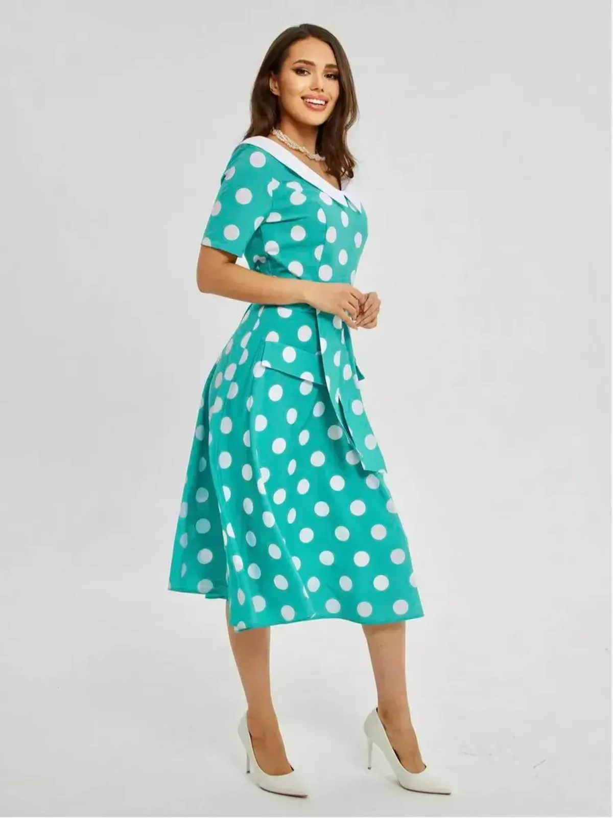 Model showcasing the Polka Grace Midi Dress with polka dots, a white collar, and tie waist for a chic summer look.