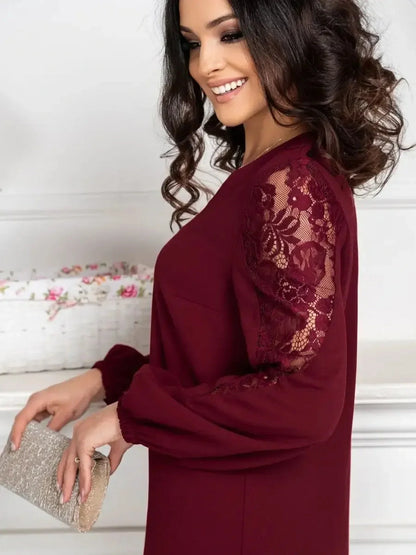 Woman wearing Lace Ruby, a deep cherry mini dress with sheer lace sleeves, perfect for weddings and special events.