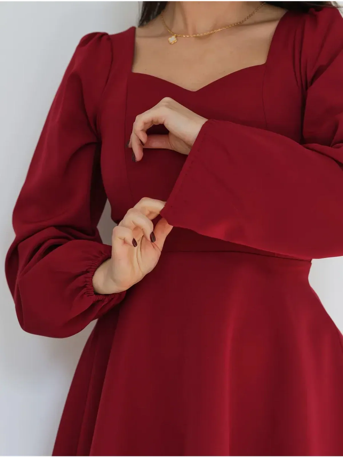 Close-up of a woman wearing a ruby red dress with a sweetheart neckline and puff sleeves, perfect for weddings or formal events.