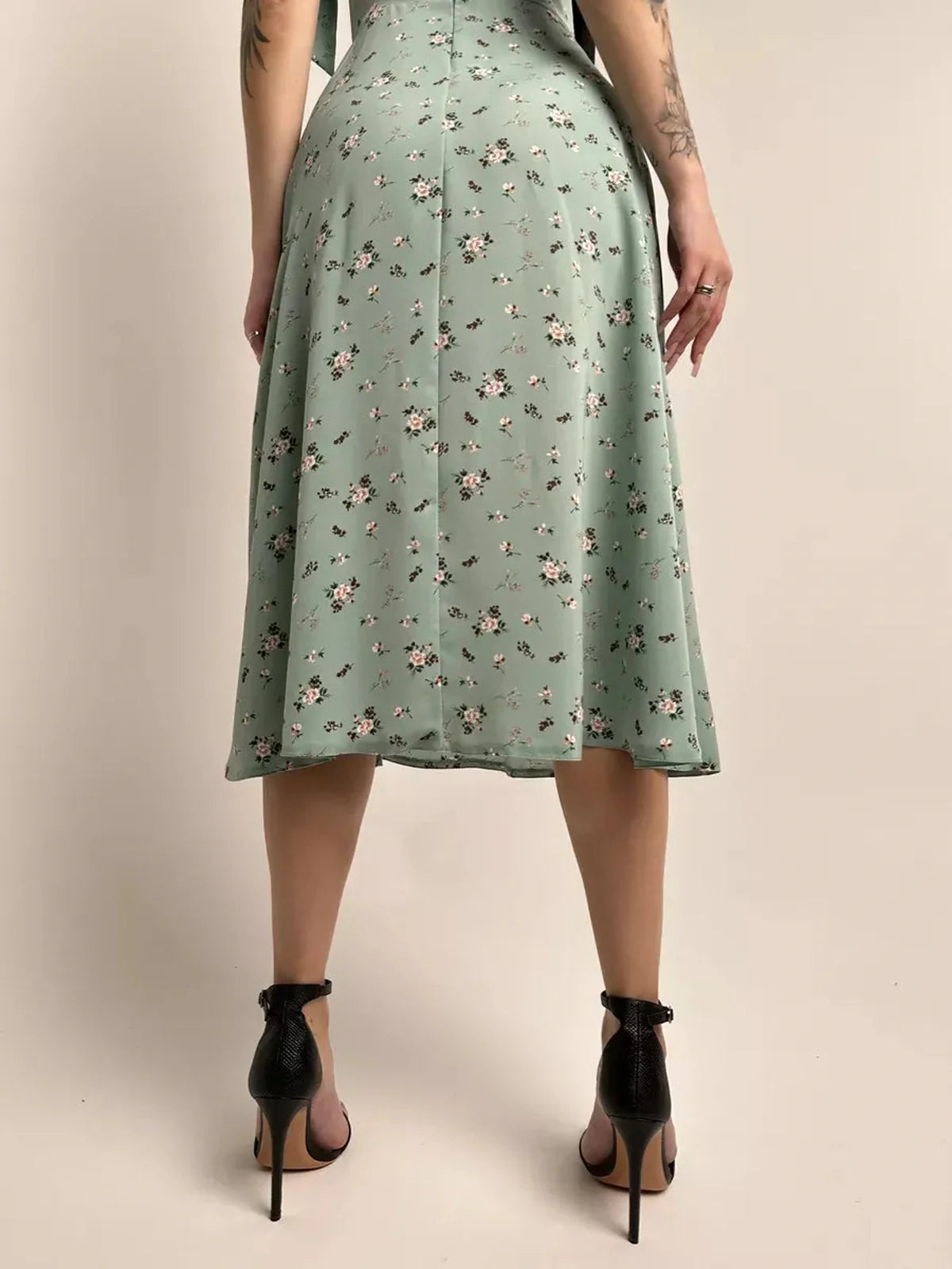 Back view of the Flora Grace Midi Dress in green with floral print, showcasing elegant A-line design and a flattering silhouette.