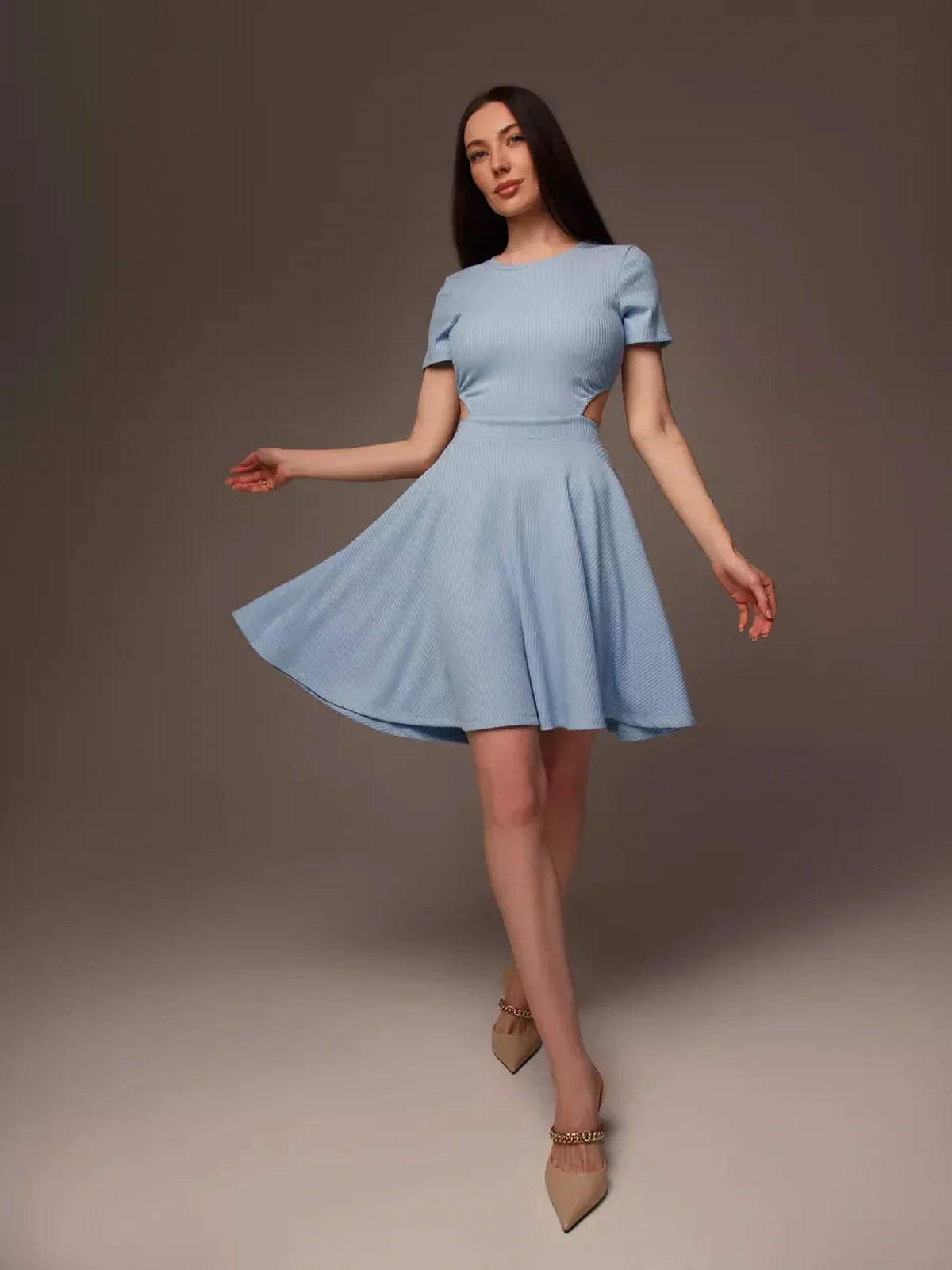Woman wearing a light blue mini dress with a cut-out waist, perfect for summer, weddings, and special occasions.