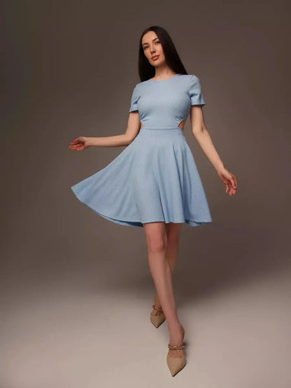 Woman wearing a light blue mini dress with a cut-out waist, perfect for summer, weddings, and special occasions.