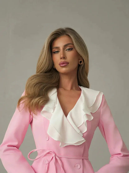 Elegant model showcasing the Rose Cascade mini dress with dramatic white ruffle neckline in blush pink.