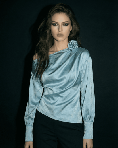 Model wearing the Celeste Blouse by Slimona, showcasing asymmetrical neckline and satin-style finish.