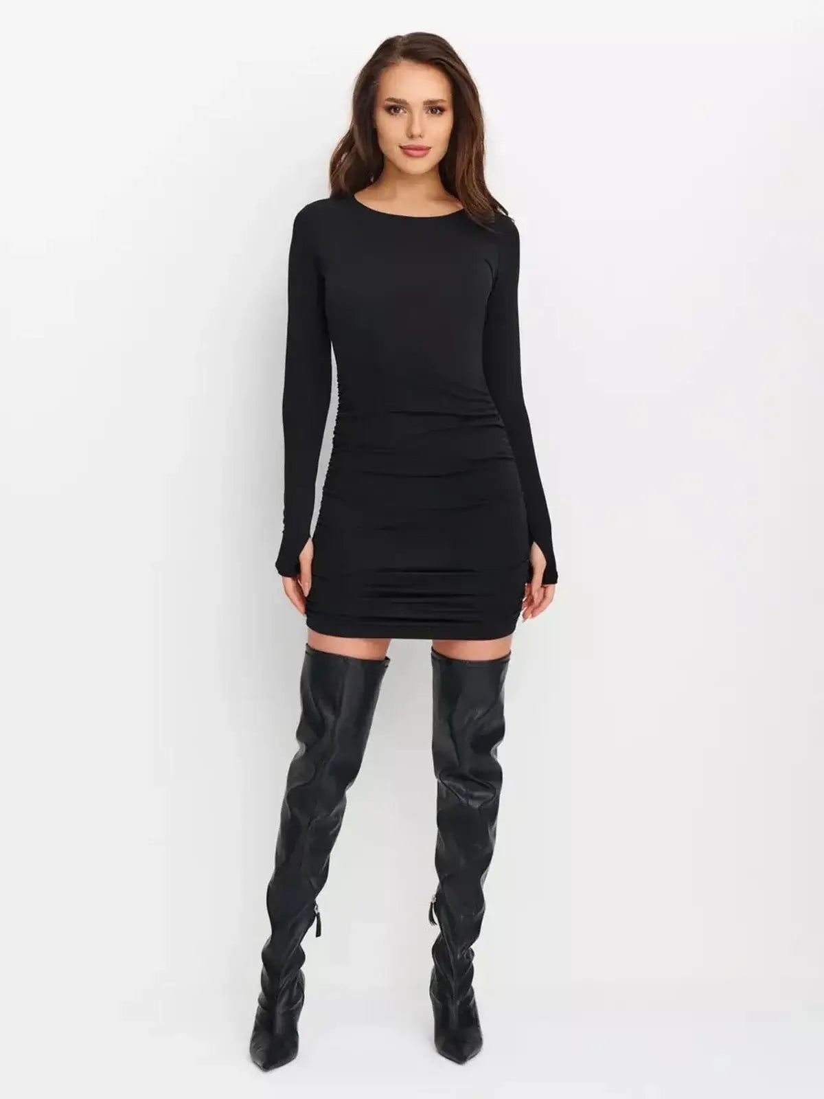 Model wearing a Sculpted Hour Mini Dress, a sleek black long sleeve bodycon dress with ruched details.