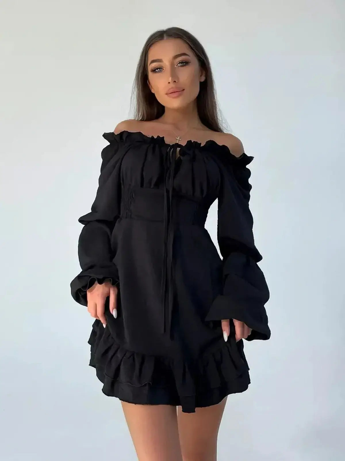 Elegant off-the-shoulder black mini dress with ruffle details and long sleeves, perfect for party and cocktail occasions.