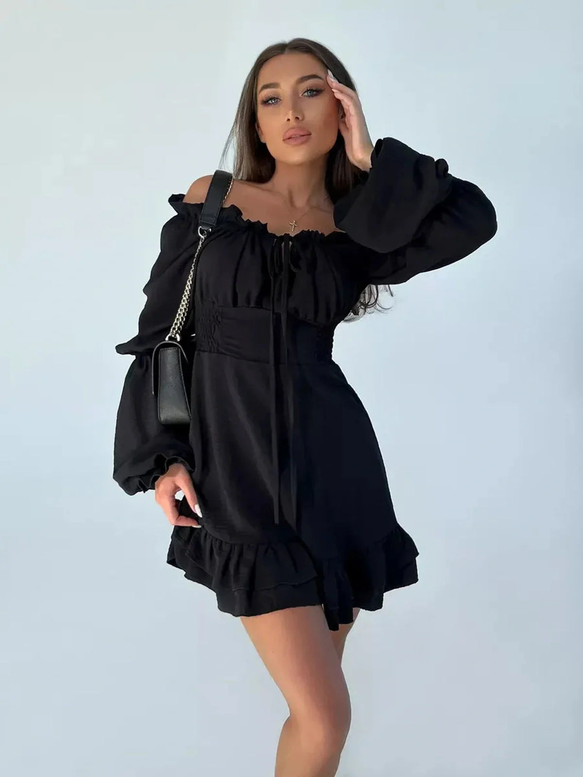 Women's black mini dress with off-the-shoulder sleeves and ruffled hem, perfect for parties and casual outings.