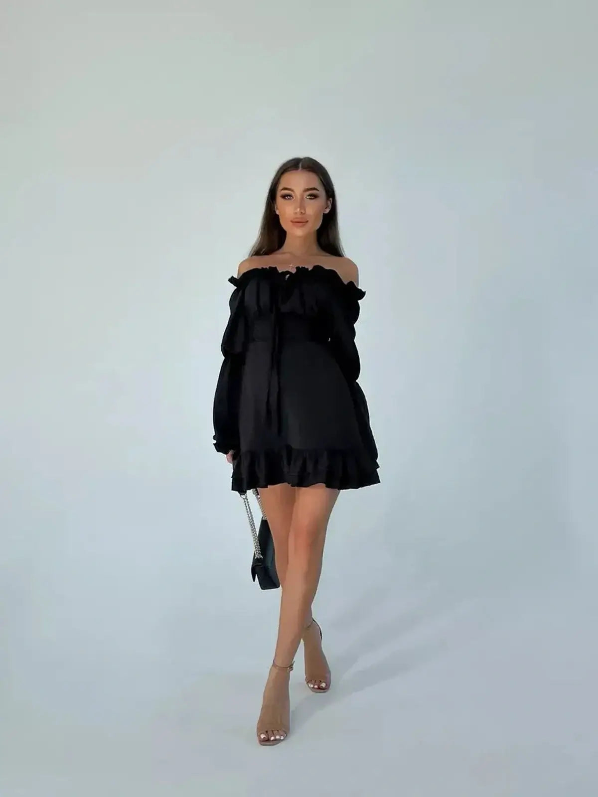 Model wearing a stylish off-shoulder black mini dress with ruffle details, perfect for summer parties and casual outings.