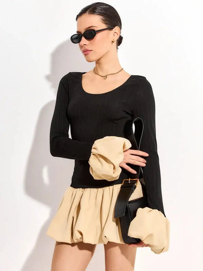 Chic black and beige mini dress with voluminous sleeves and a fitted waist, perfect for summer events and parties.