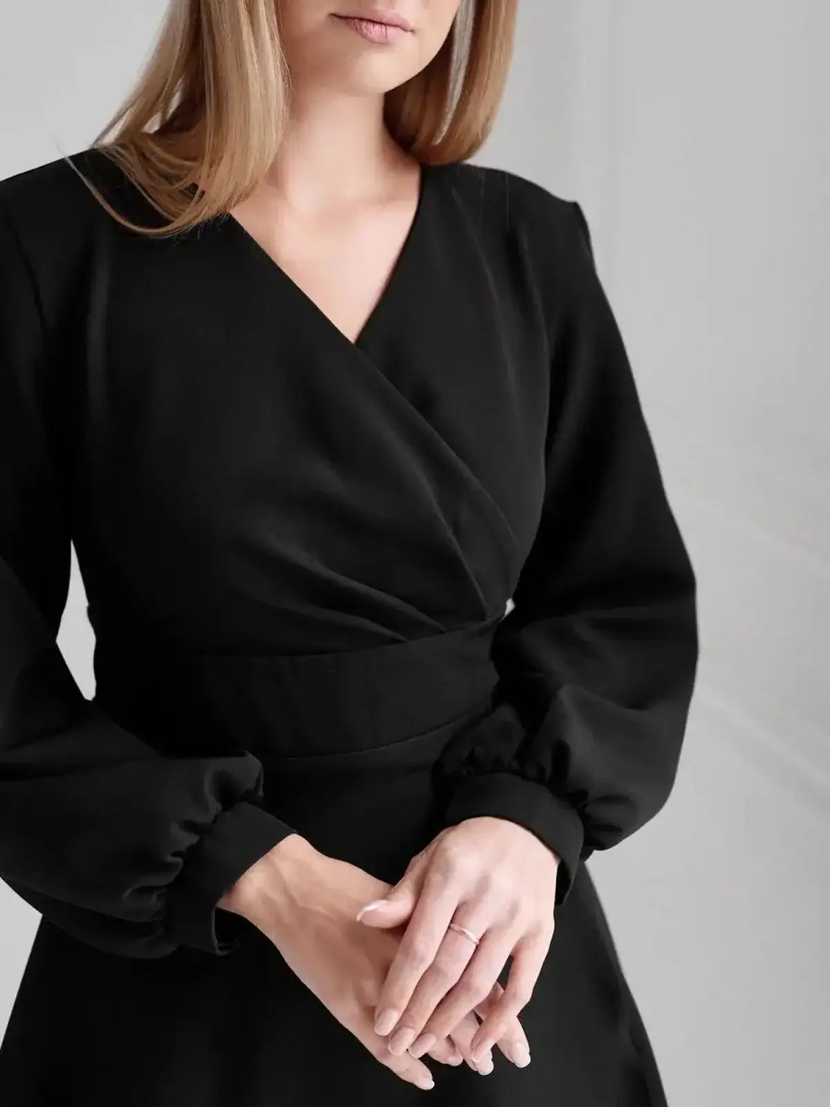 Elegant black midi dress with V-neckline and puff sleeves, perfect for wedding guests and formal events.