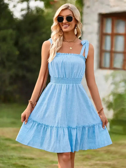 Light blue sundress with adjustable straps and ruffled hem, perfect for summer outings and cocktail events.