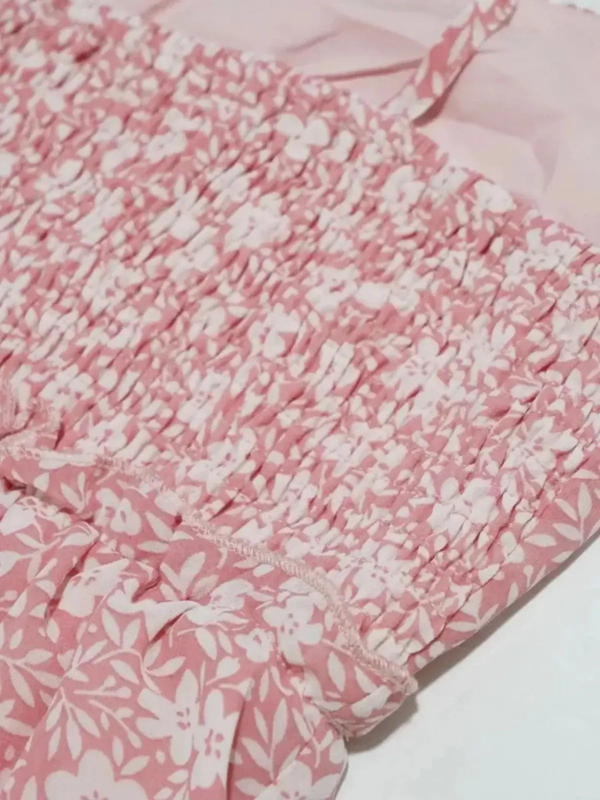 Close-up of the pink floral fabric and ruched bodice of the Blush Bloom dress, perfect for summer gatherings.