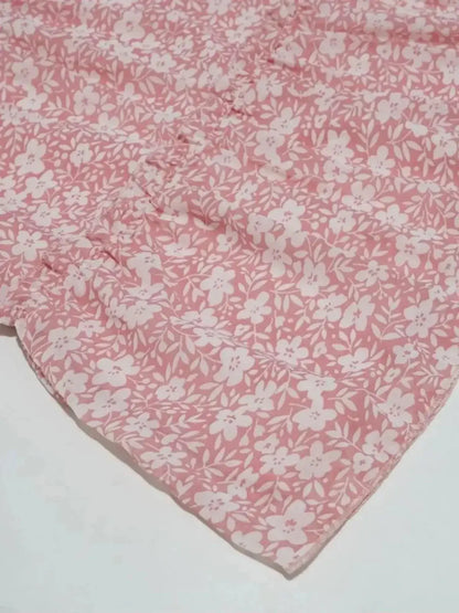 Close-up of Blush Bloom floral fabric in soft pink, showcasing delicate patterns for trendy summer dresses.