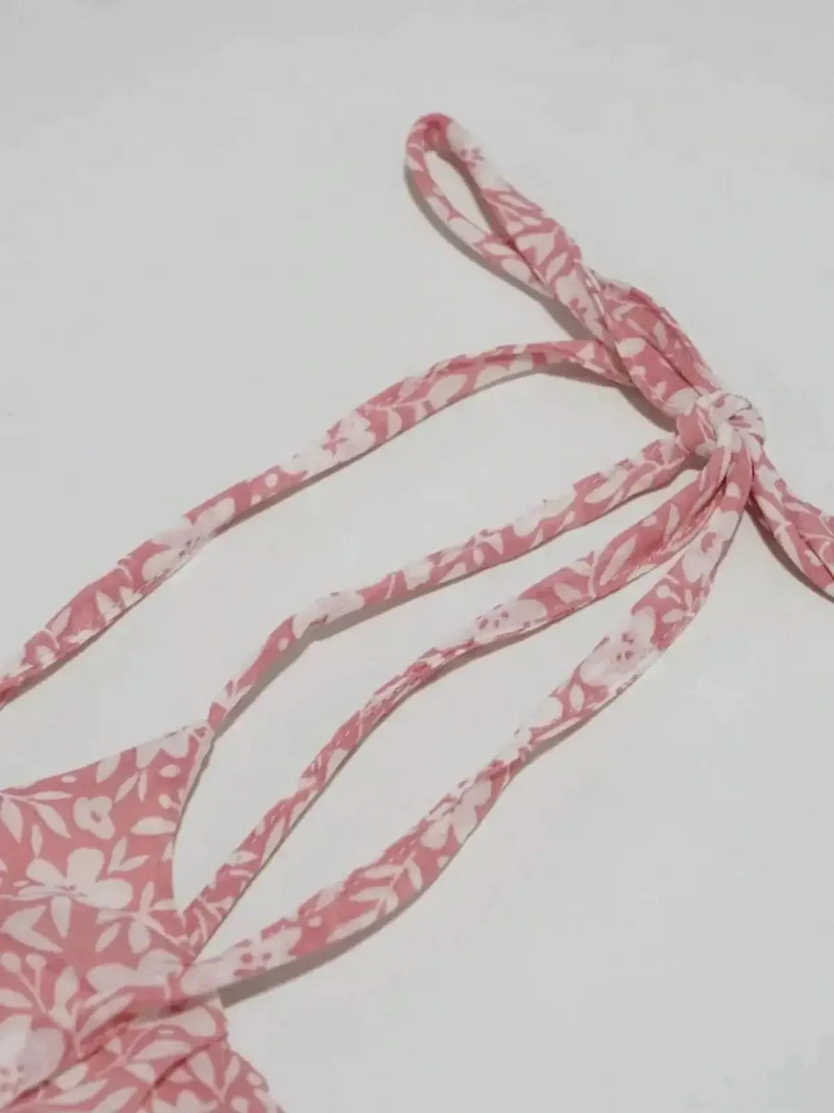 Close-up of the tie straps on a pink floral dress, perfect for summer occasions and garden parties.