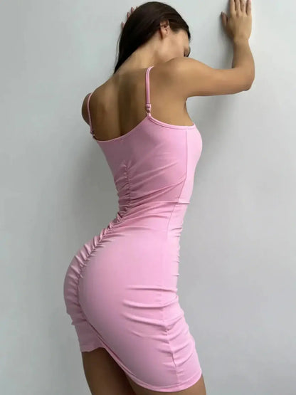Back view of a figure-hugging pink mini dress with ruched detailing, perfect for summer parties and wedding guest outfits.