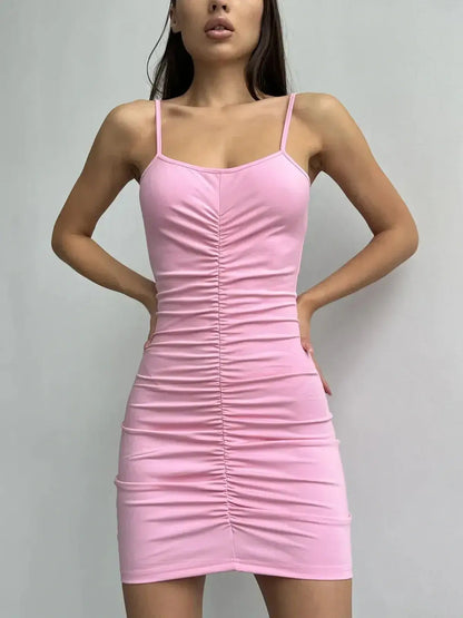 Pink bodycon mini dress with adjustable spaghetti straps and flattering ruching for women.