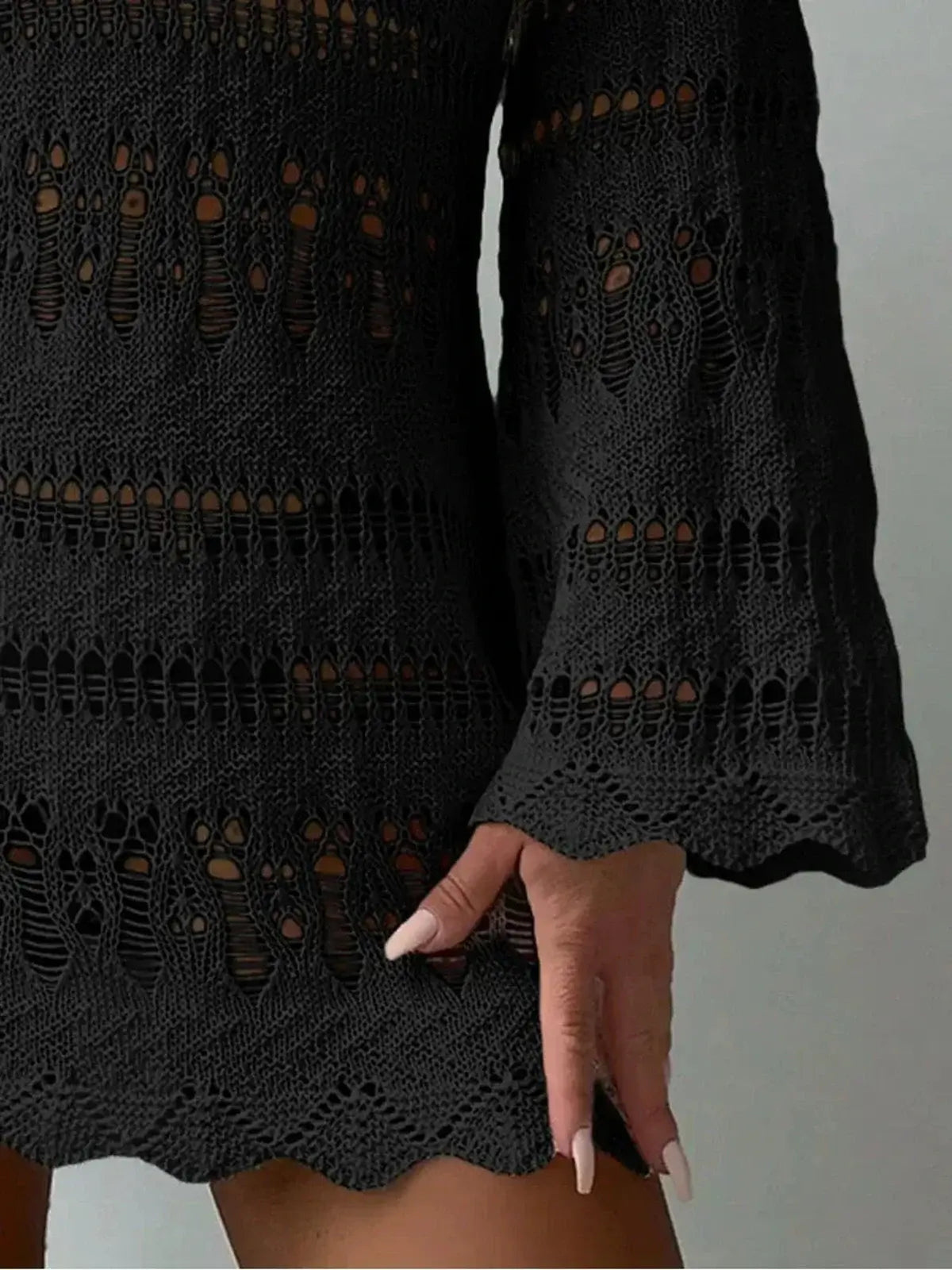 Close-up of black bell sleeve dress with openwork patterns, showcasing a chic bohemian style.