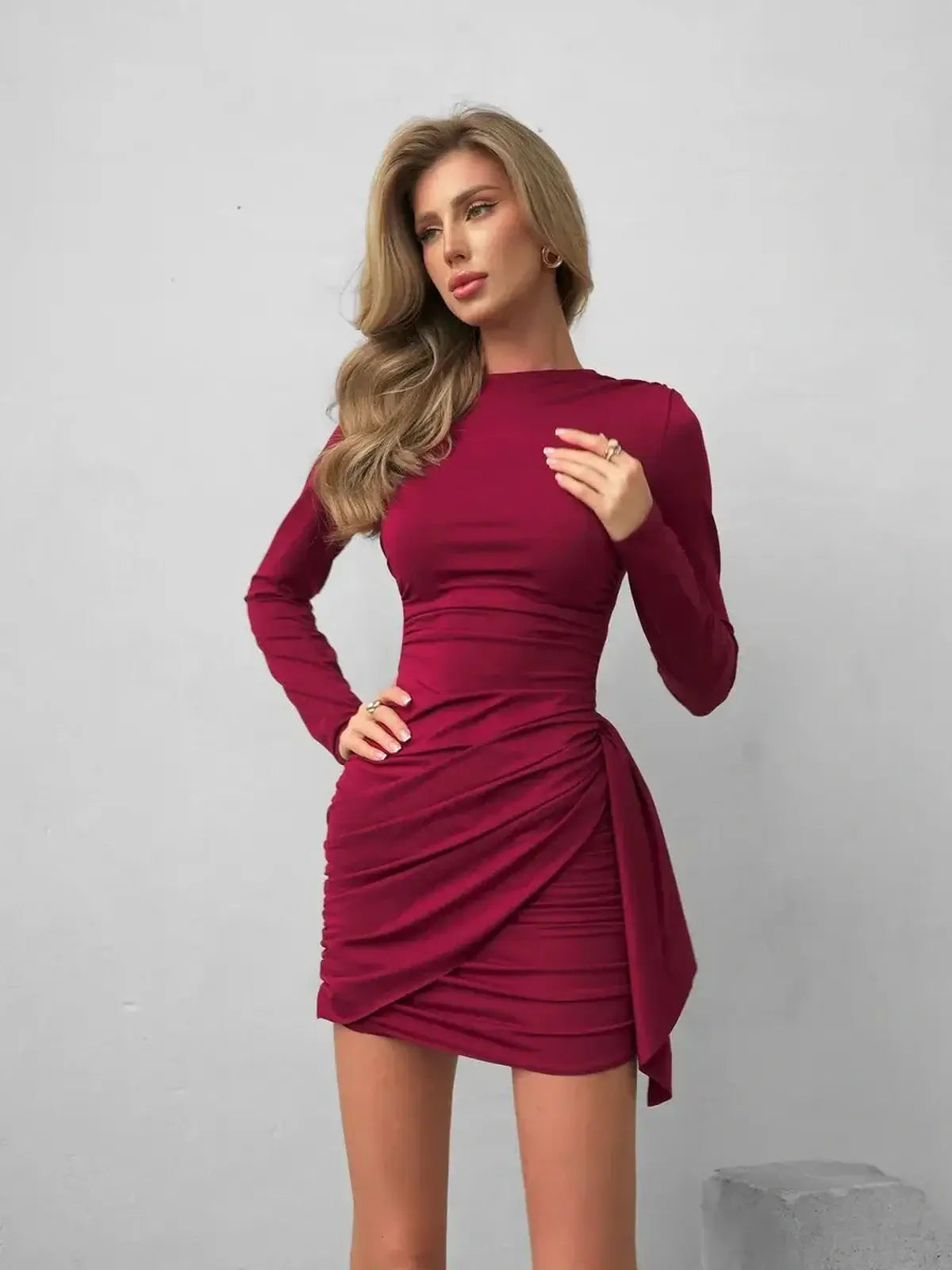 Burgundy Grace mini dress featuring bodycon silhouette, elegant ruching, and sophisticated tied waist sash.