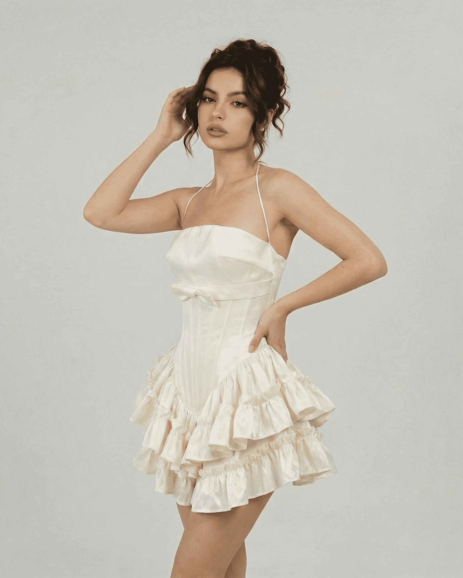 Celeste Mini Dress by Slimona, corset-inspired tiered design in soft white, featuring a sculpted bodice and halter straps.
