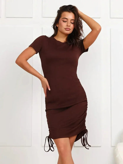 Model wearing Cocoa Cinch brown mini dress with adjustable ruched skirt and short sleeves.