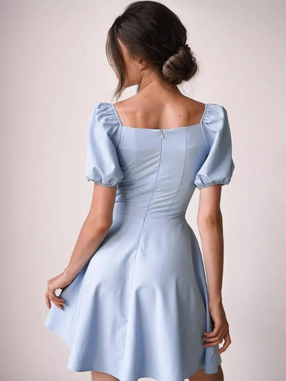 Back view of a light blue mini dress with puff sleeves and a flared skirt, perfect for summer occasions.