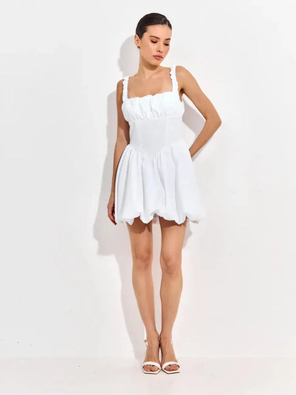 White mini dress with ruffled straps and sculpted bodice, perfect for wedding guests and summer parties.