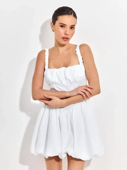 Whimsical white mini dress featuring a square neckline, soft ruching, and ruffled straps, perfect for summer celebrations.