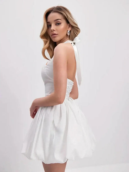 Model wearing the Cloud Belle white mini dress with halter neckline, voluminous bubble hem, perfect for summer or wedding events.