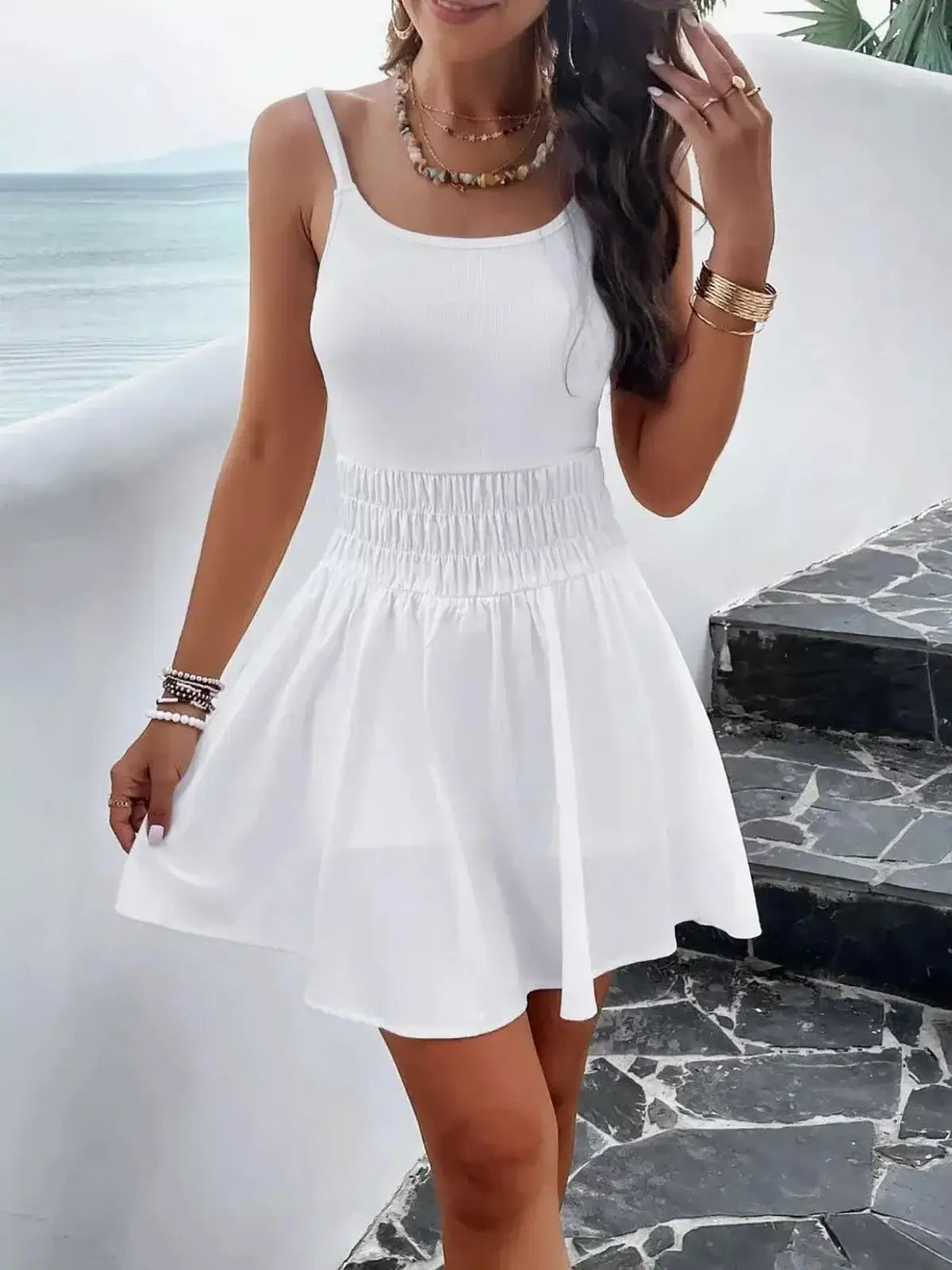 Woman wearing the Coconut Shore Mini Dress, a stylish white summer dress with a flowy skirt and ribbed bodice.