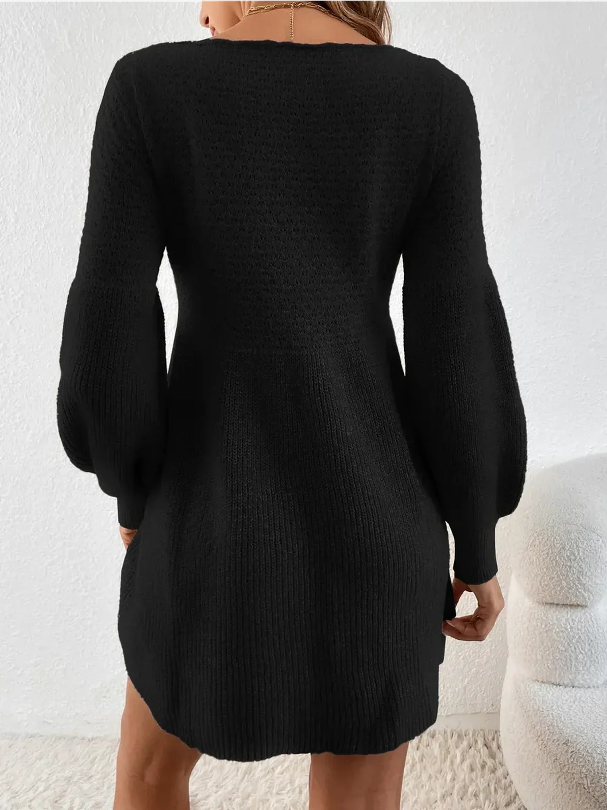 Back view of a cozy black mini dress with balloon sleeves, perfect for winter occasions and elegant outings.